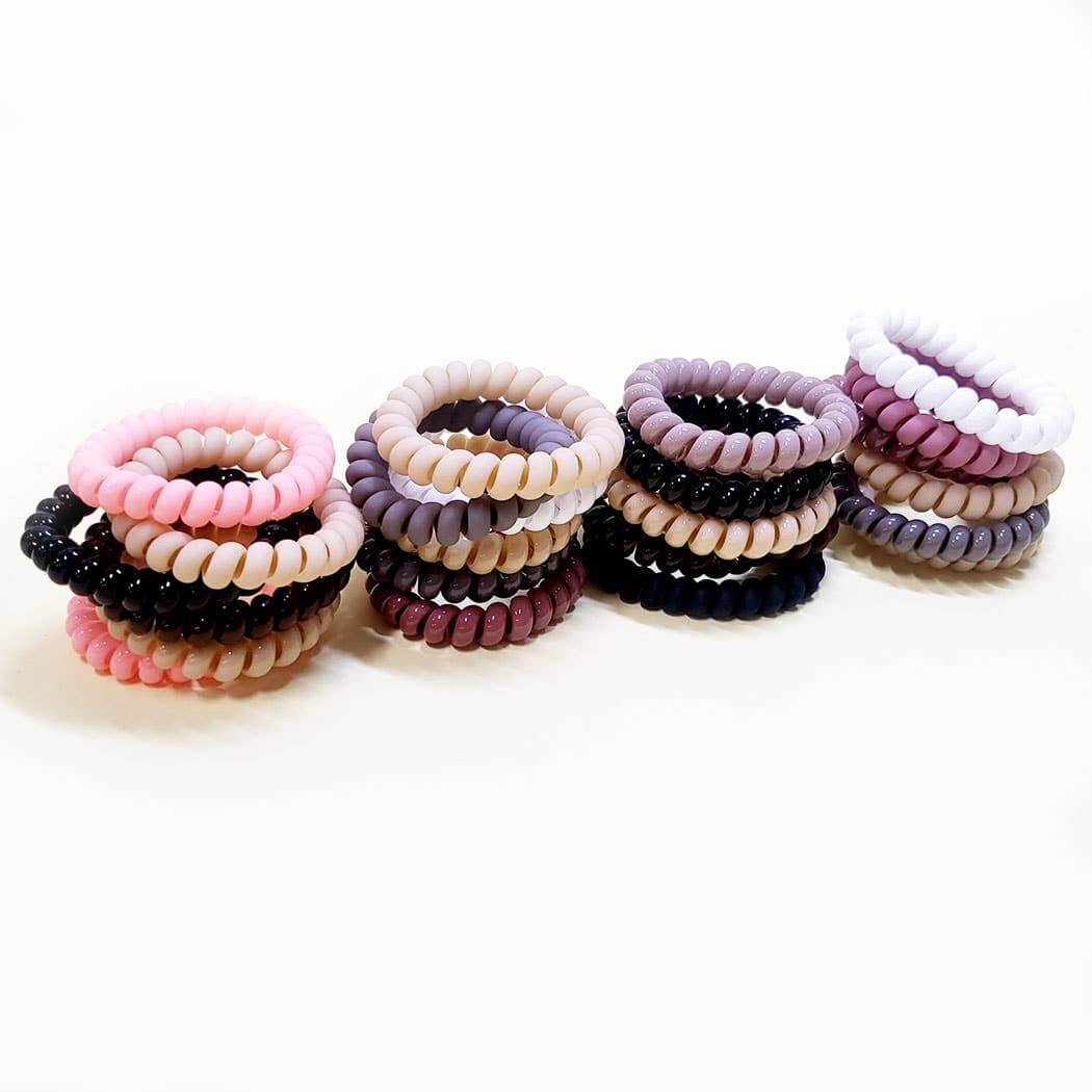 Assorted Twist & Tell hair ties in neutral and pastel colors, perfect for secure and gentle ponytail styles.