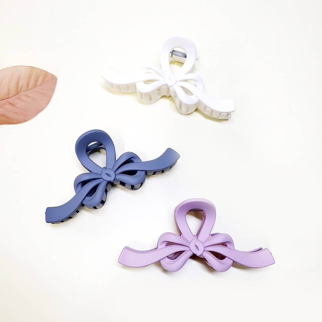 Set of three Ribbon Revival matte bow claw clips in white, navy, and lavender colors.