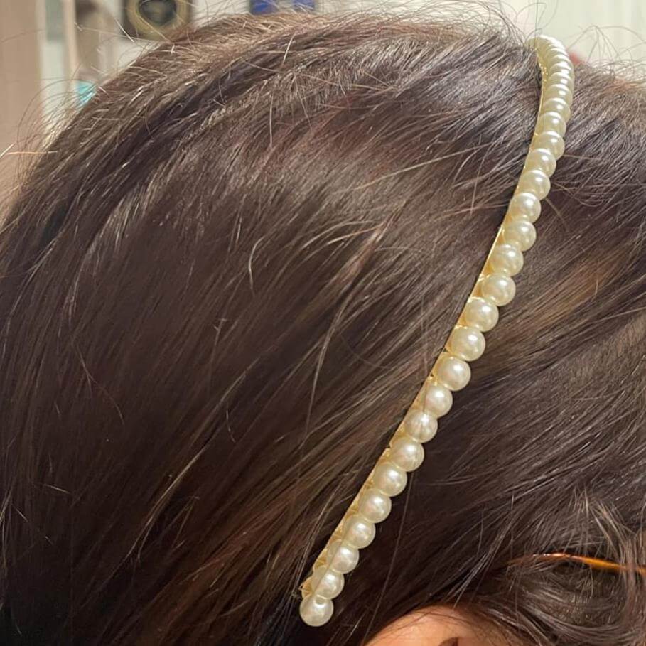 Pearl embellished hairband worn elegantly in hair, adding sophistication to any holiday outfit.