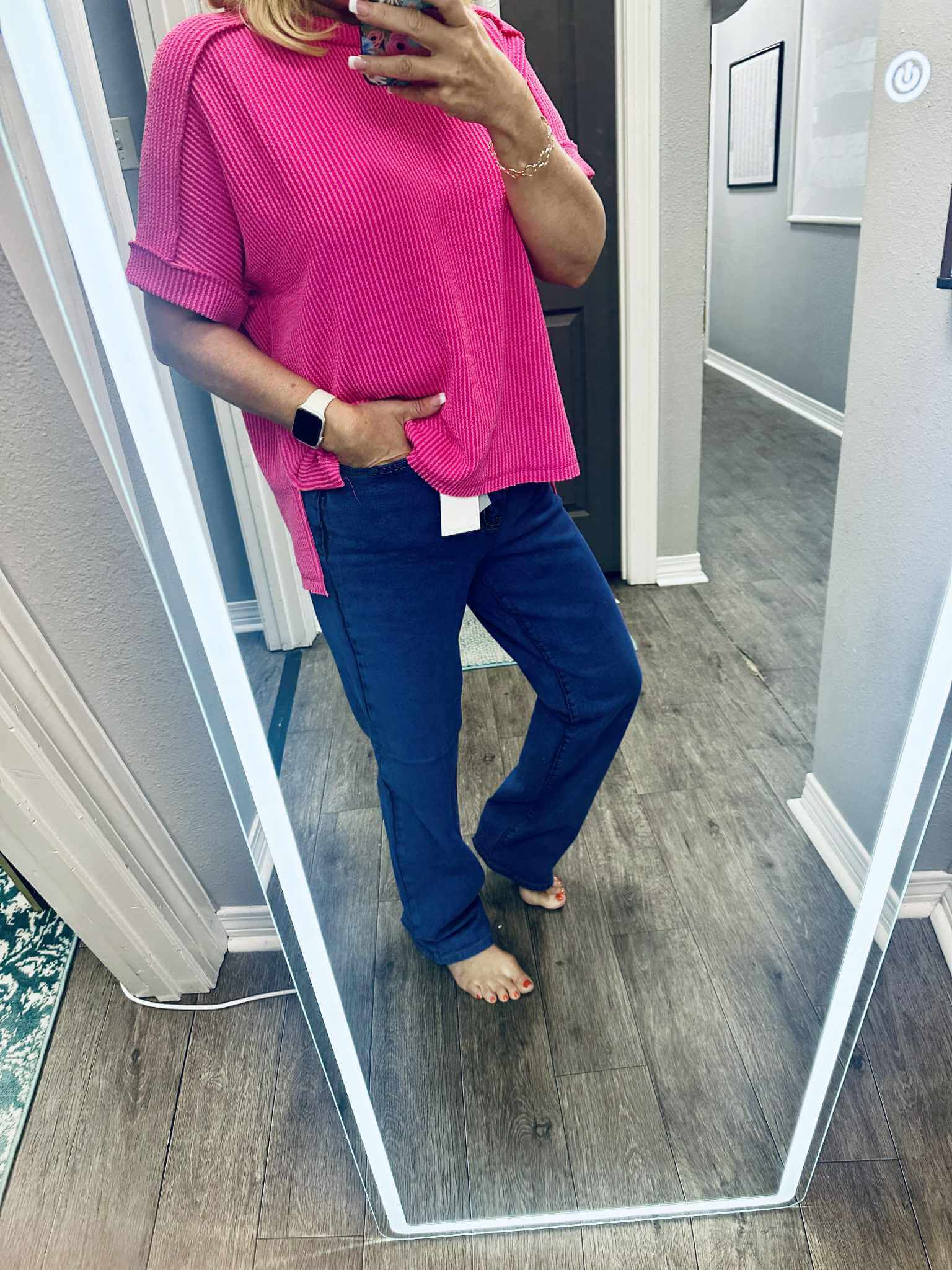 Model wearing LILA HIGH RISE DAD JEANS with a pink top, showcasing a stylish outfit in a mirror reflection.