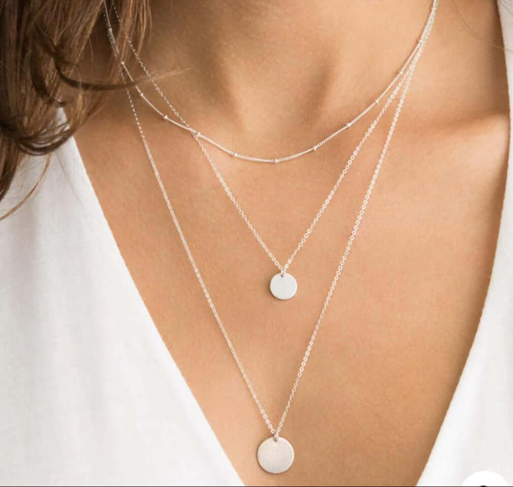 Infinitely Faithful Necklace Set featuring layered chains and polished disc pendants in a minimalist style.