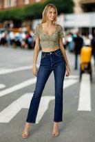 Model wearing midrise ADELINE Jeans by Risen paired with a cropped top in a busy urban setting.