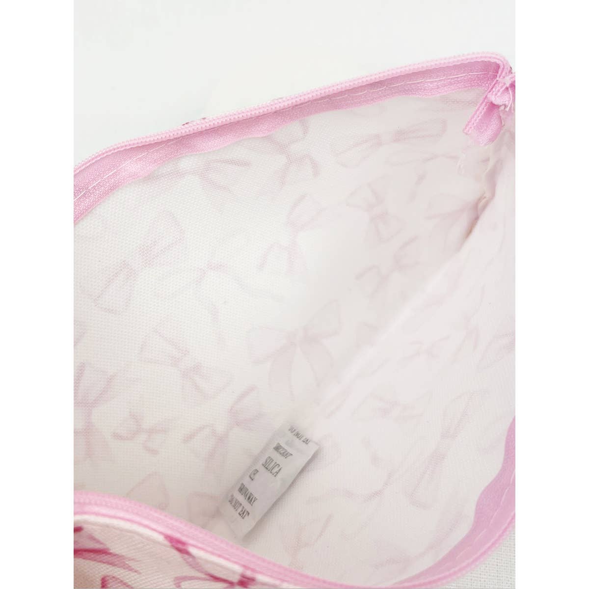 Interior view of the BOW ME OVER COSMETICS BAG showing a pink bow design, ideal for organizing makeup essentials.