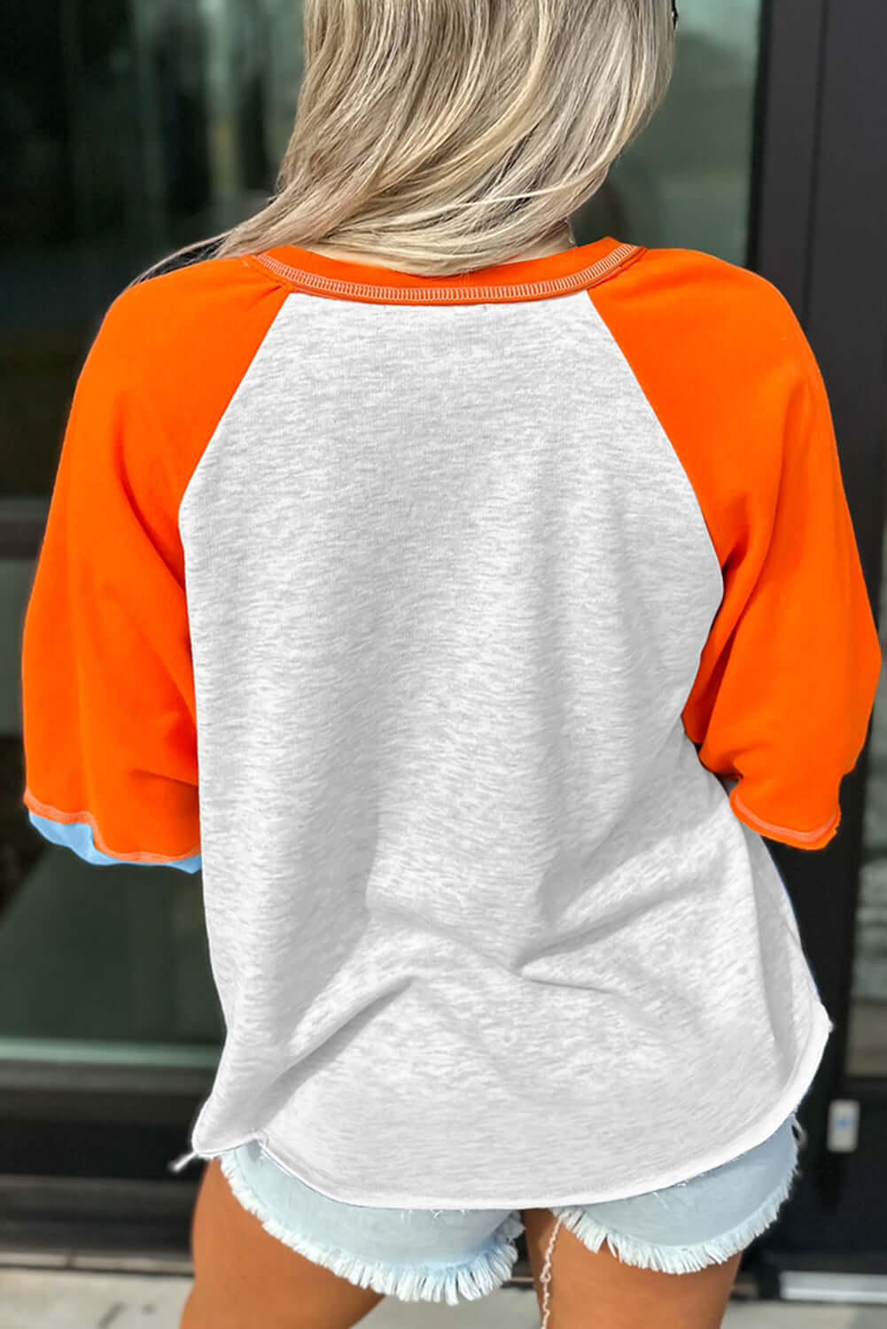 CITRUS CRUSH TOP featuring bold tangerine sleeves and light grey body, ideal for casual comfort and playful style.