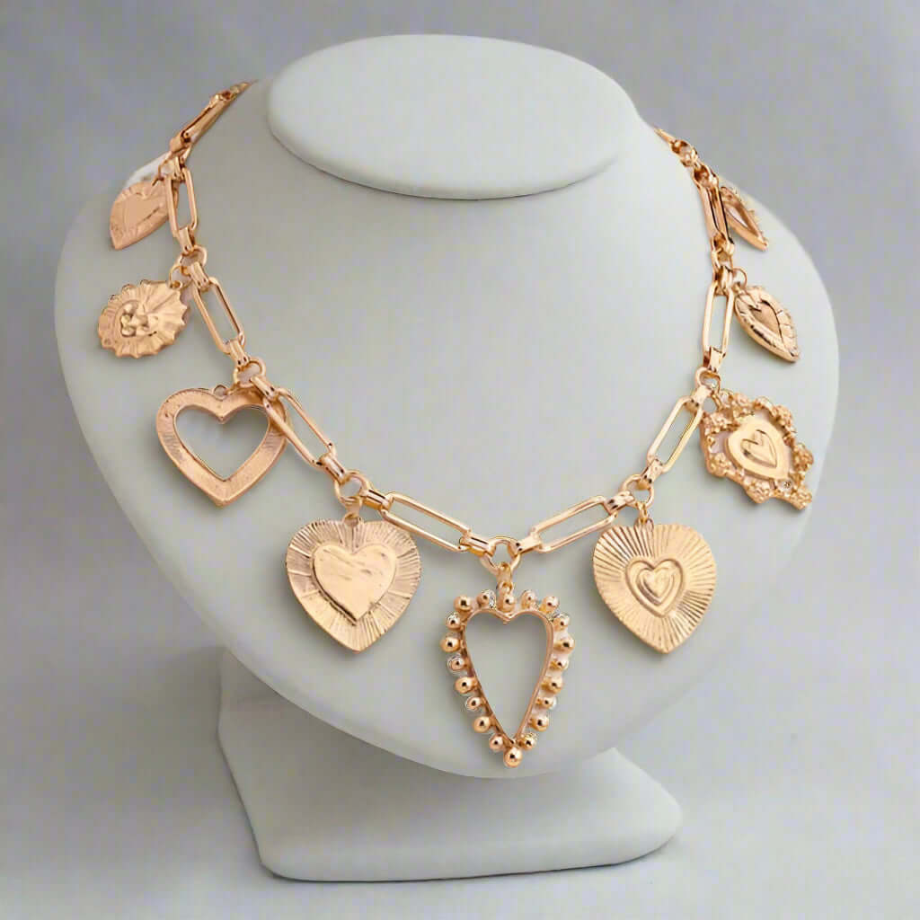 HEART TO HEART CHARM NECKLACE featuring gold-tone heart pendants on a paperclip chain, perfect for adding whimsy and romance.