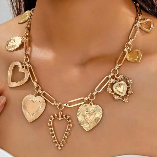 Gold-tone HEART TO HEART CHARM NECKLACE with assorted heart pendants on a paperclip chain.