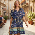 Woman wearing FINALLY MINE - UMGEE boho chic floral mini dress in a charming street setting.