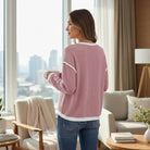 Woman wearing a Blushline Beauty Top, showcasing its soft knit texture and stylish contrast trim in a cozy indoor setting.