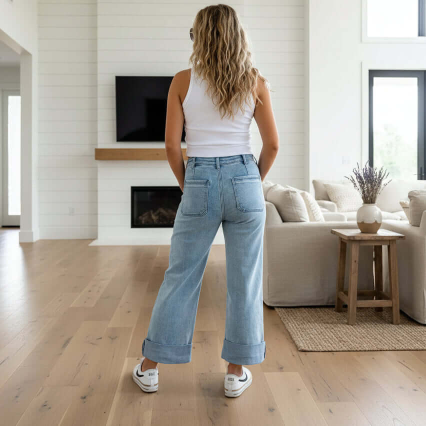 Back view of a woman wearing BLAKELY CLOVER FRONT POCKET JEANS in a stylish living room.
