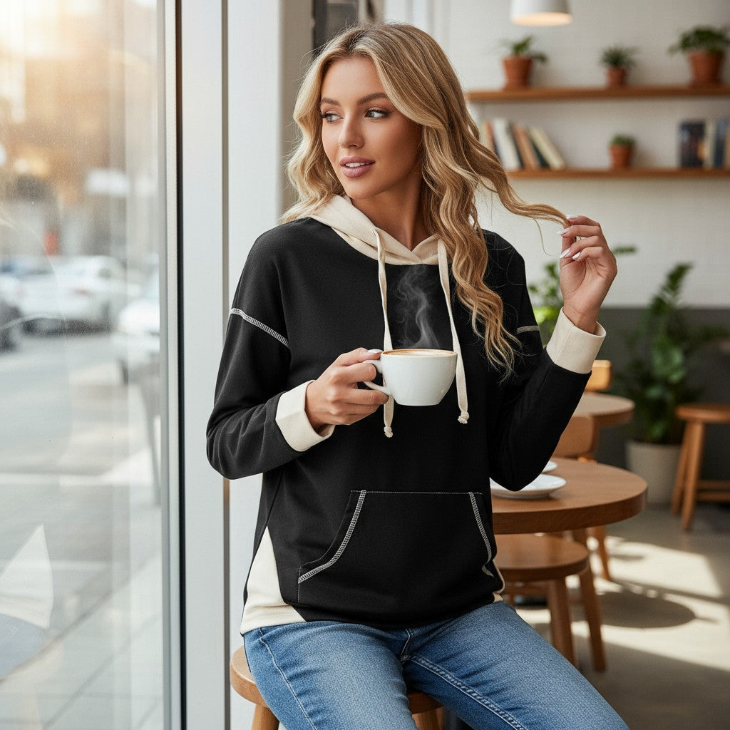 Modern Edge Hoodie worn by a woman with a cup in a cozy café setting, showcasing its stylish design and comfort.
