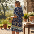 Model wearing FINALLY MINE - UMGEE dress in floral print outdoors, holding a basket, enjoying a sunny day.