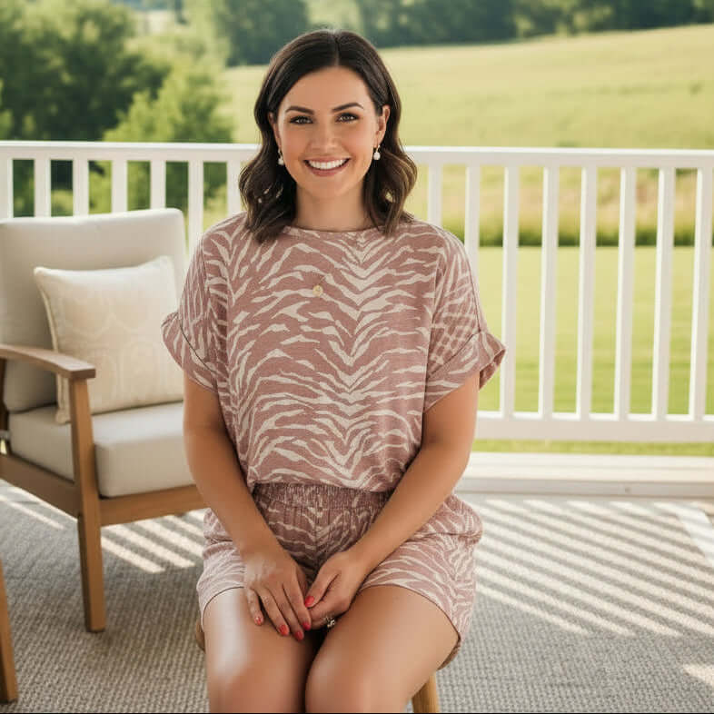 Model showcasing the WILD WHISPER 2 PIECE SET, featuring a chic print and relaxed fit on a sunny porch.