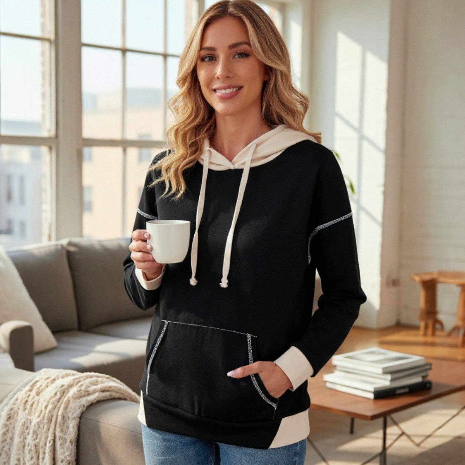 MODERN EDGE HOODIE model enjoying coffee in a stylish, cozy interior with bright lighting.