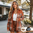 Woman wearing HARVEST HAVEN JACKET with rust colorblock plaid, styled with a white top and brown shorts in a cozy outdoor setting.