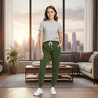 Model wearing OLIVE YOU JOGGERS, soft olive jogger sweatpants, in a cozy living room with city view.