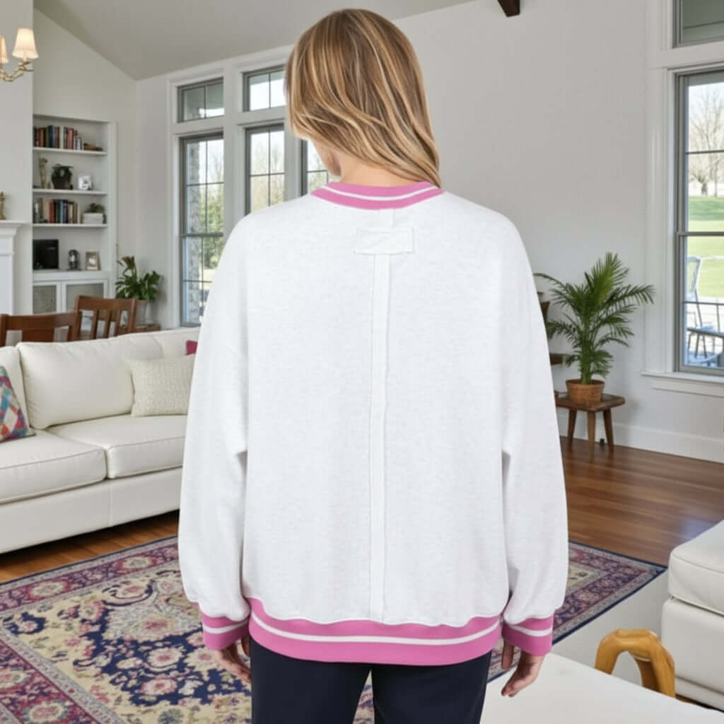 Back view of a woman wearing DAYDREAM BELIEVER - Sage + Fig (gray) pullover in a cozy modern living room.