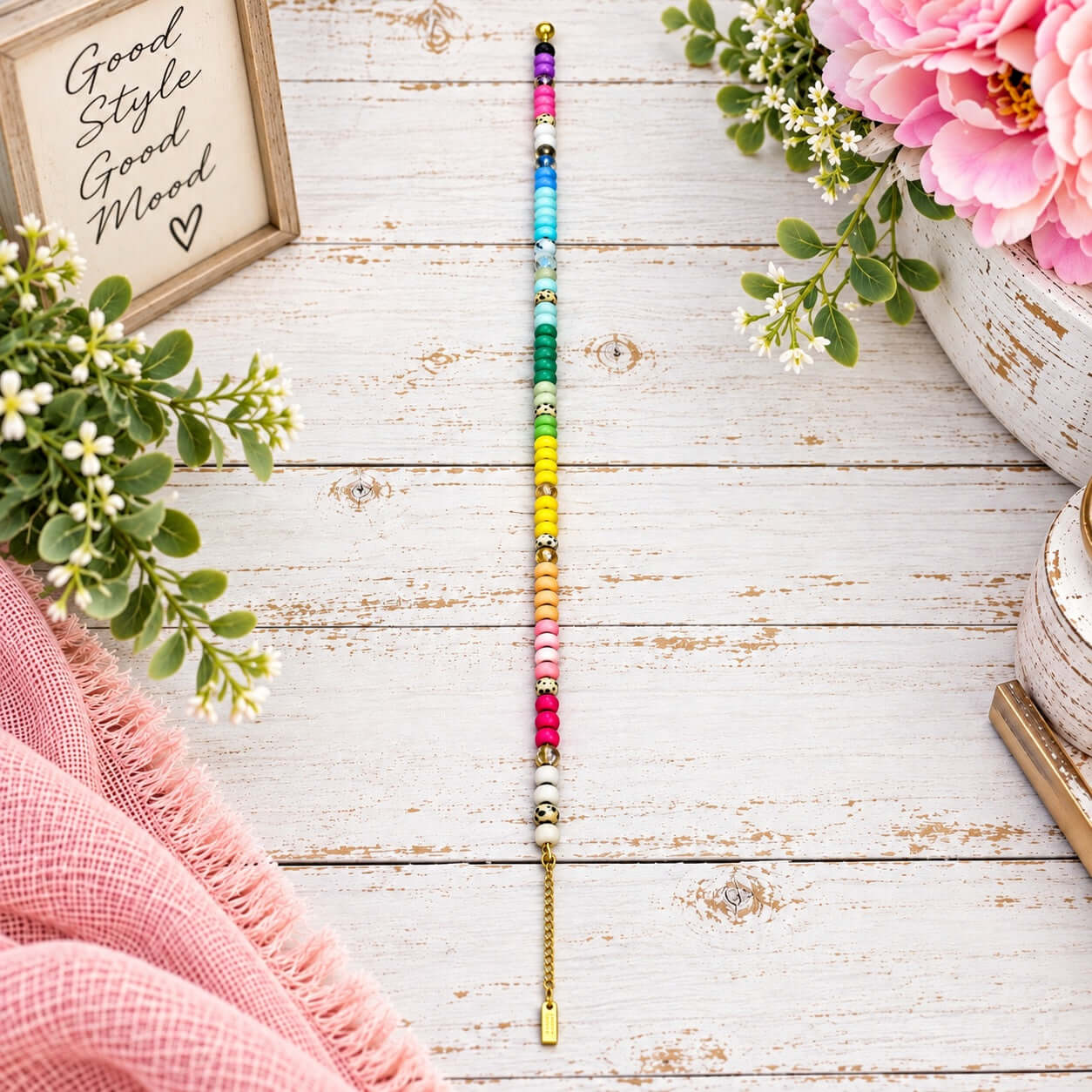 COLOR ME HAPPY NECKLACE with colorful beads and gold-tone details on a rustic wood surface.
