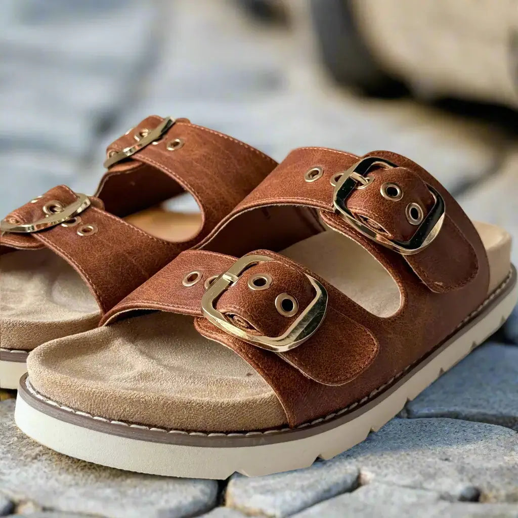 Feelin' Saucy sandals by Corkys featuring brown straps and shiny gold buckles on a cushioned footbed.