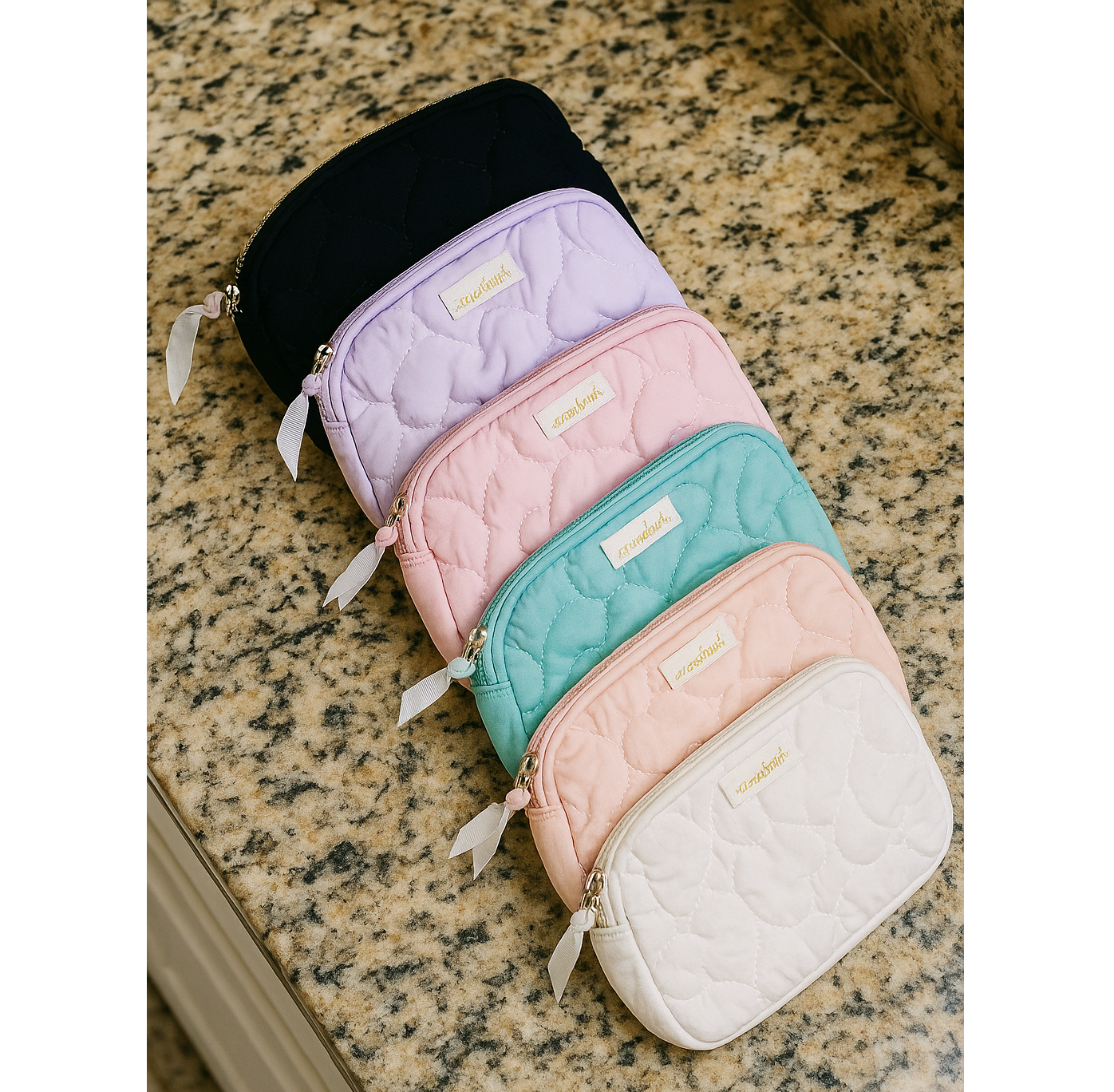 Colorful Love Language Makeup Bags in various shades on a countertop, showcasing quilted heart patterns.