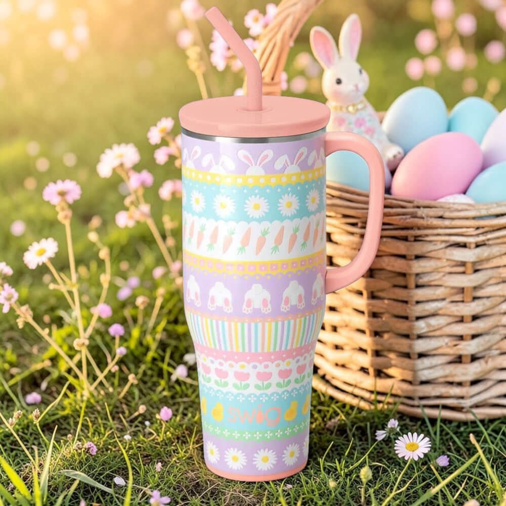 BUNNY TRAIL 40 OZ MEGA MUG - Swig Life in a garden with Easter decor, featuring bunnies, carrots, and flowers.