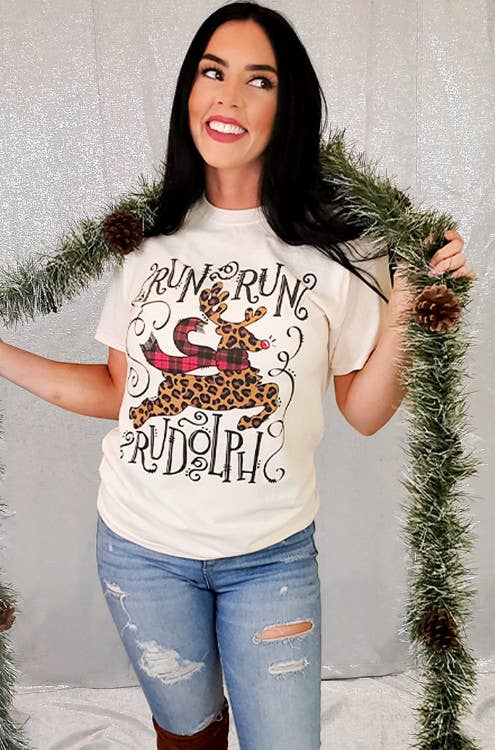 Woman wearing Run Run Rudolph Christmas T-shirt with festive decor, showcasing a fun holiday style.