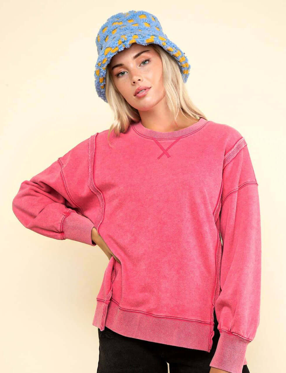 Model wearing the pink Flex Time Crew Neck sweatshirt with stylish stitch details and a blue bucket hat.