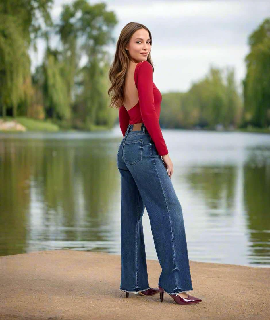 Model wearing JUDY BLUE Mia dark wash midrise jeans with wide leg cut by the water, showcasing style and fit.