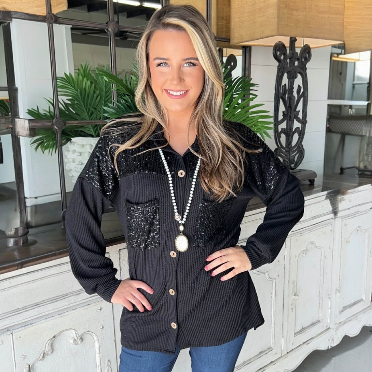 Model showcasing the CITY LIGHTS TOP, a black corded shacket with sequin patch pockets, styled with casual elegance.