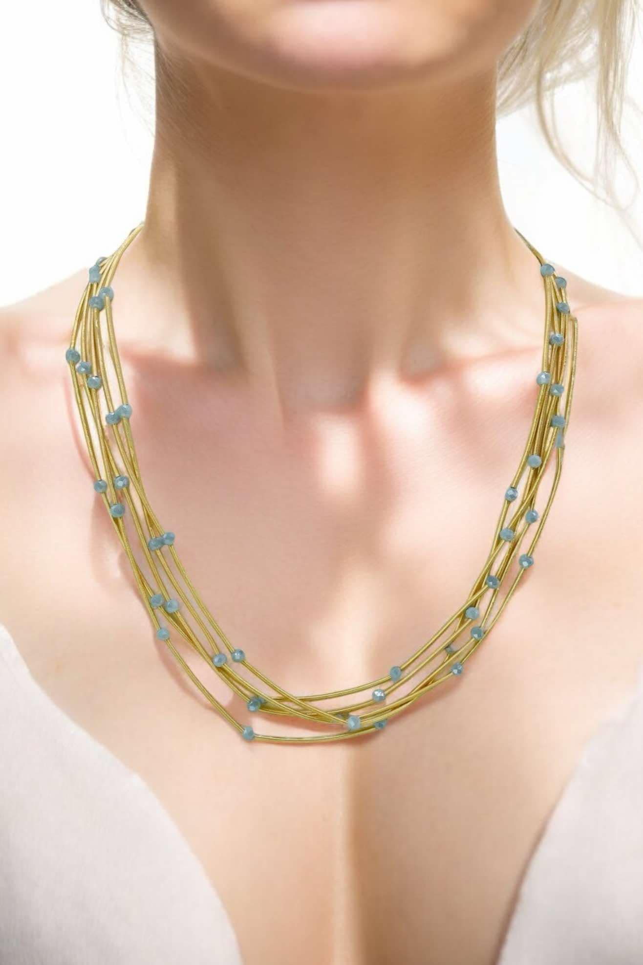 Gold tone multi-strand necklace with glass beads, adding style and glam to any outfit. 22 inches long, adjustable.