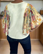 Back view of a woman wearing the Sun Dance top with floral patchwork batwing sleeves.