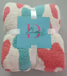 Colorful Dixie Bella throw blanket wrapped with ribbon, showcasing ultra-soft microfiber material and playful design.