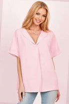Beautiful model wearing a pink DAYBREAK DARLING top with a collared neckline and relaxed sleeves, perfect for casual outings.