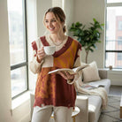 Woman enjoying coffee in a cozy fall outfit featuring the WILD HARVEST VEST - Umgee, layered over a long sleeve top.