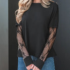 Simply Enchanted Top with sheer lace mesh sleeves, soft solid black body, and feminine charm.