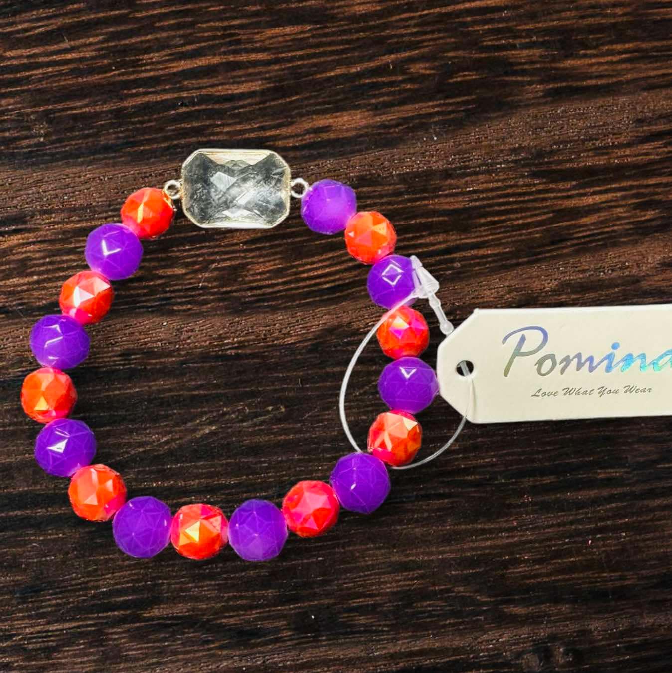 Colorful Level Up Pomina Bracelet with purple, orange beads and a large rectangular glass gemstone.