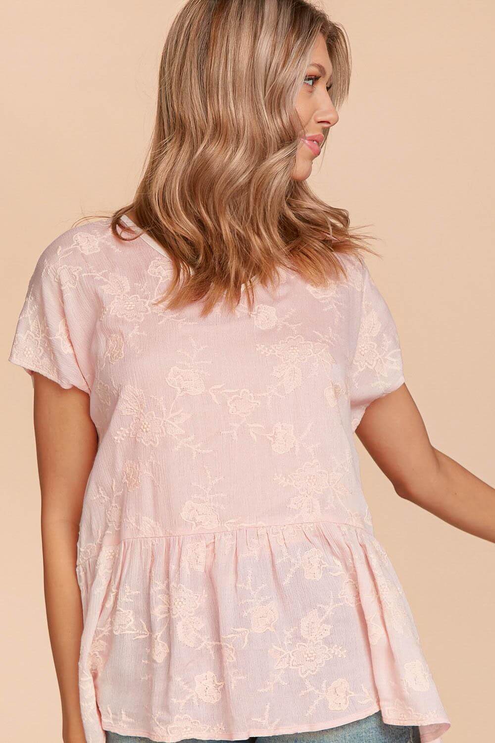 Model wearing pink Grace & Glam Top by Haptics featuring floral embroidery and a flowy peplum silhouette.