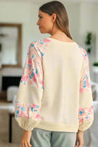 Stylish woman wearing a lightweight vanilla top with floral patchwork and balloon sleeves, showcasing a trendy design.