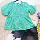 Turquoise checkered Aqua Angles top by Umgee with puff sleeves, styled with black shorts and white sneakers.