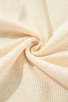 Close-up of lightweight ribbed fabric in a soft vanilla shade, showcasing its texture and elegant design.