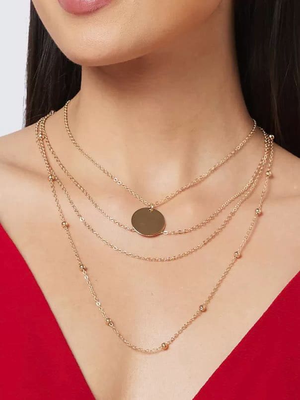 Layered gold Around The World necklace set featuring a round pendant and delicate chains.