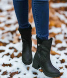 Very G North Park black boots featuring fur lining, styled with jeans on a snowy ground. Cozy and versatile winter footwear.