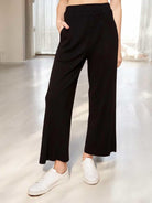 Easy Living ribbed pants by Sugarlips in black, featuring a wide leg and elastic waist, styled with white sneakers.