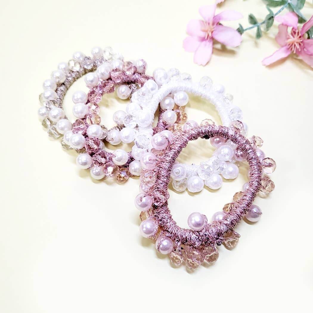 Elegant Charmed Twists hair ties with glass beads and faux pearls in pastel colors for stylish ponytail holders.