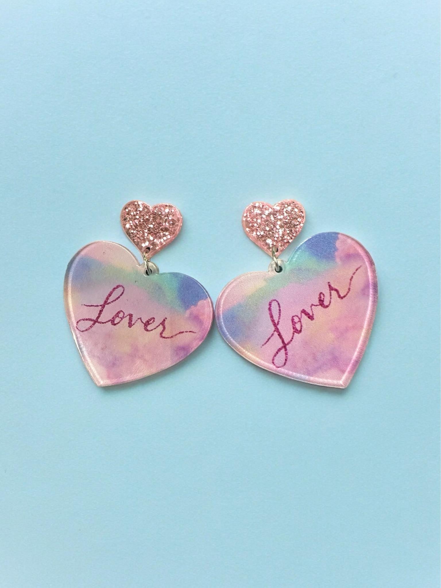 LOVER ERA Earrings in pastel colors with glittery heart accents, perfect for making a stylish statement.