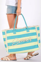 Model holding MB0267 Sewn Tope Summer Tote Bag with fringe and striped design, perfect for beach outings.