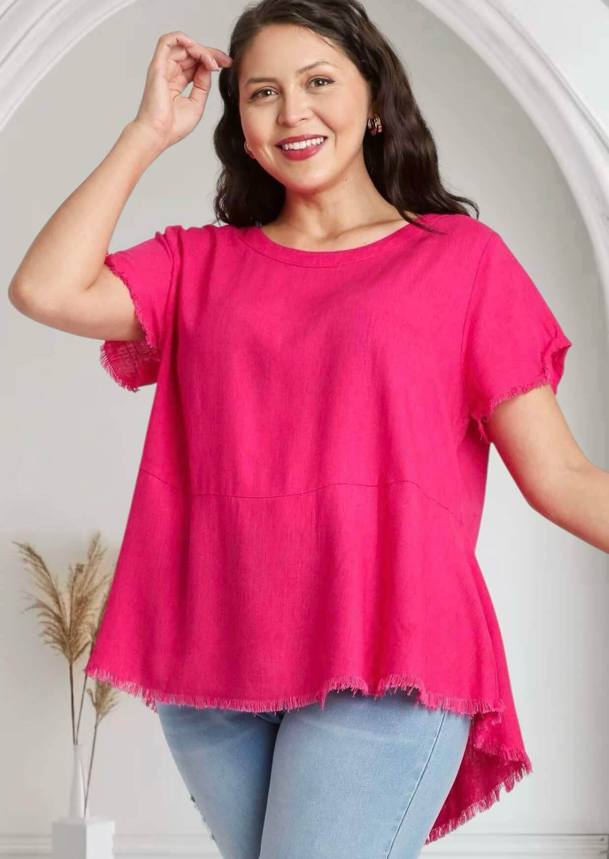 Model in hot pink GLORIOUS FEELING top by Umgee with frayed hem and round neck, styled with jeans.