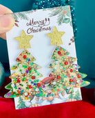 Star On Top Christmas Tree Earrings in gold with colorful rhinestones on a festive Merry Christmas card.