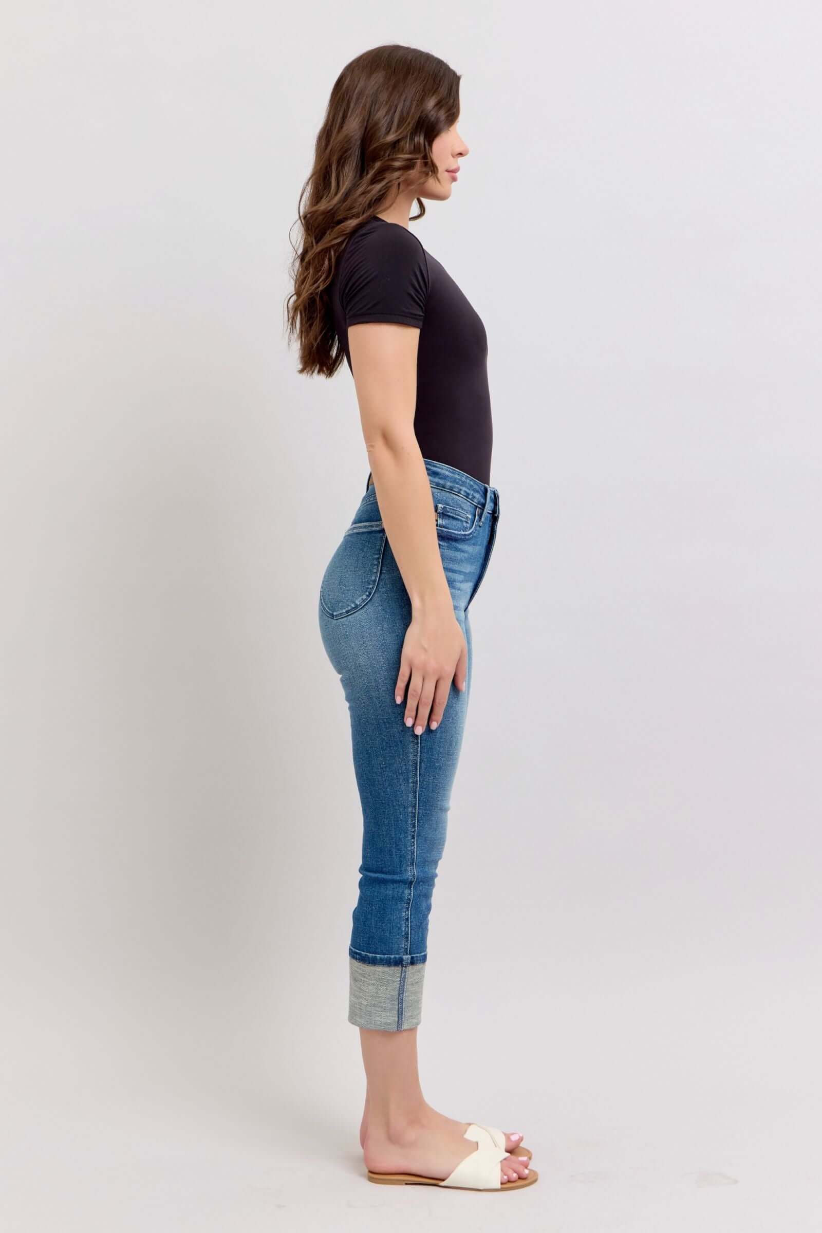 Side view of woman wearing high waist Judy Blue Charli Capris, cuffed, showing tummy control and medium wash denim.