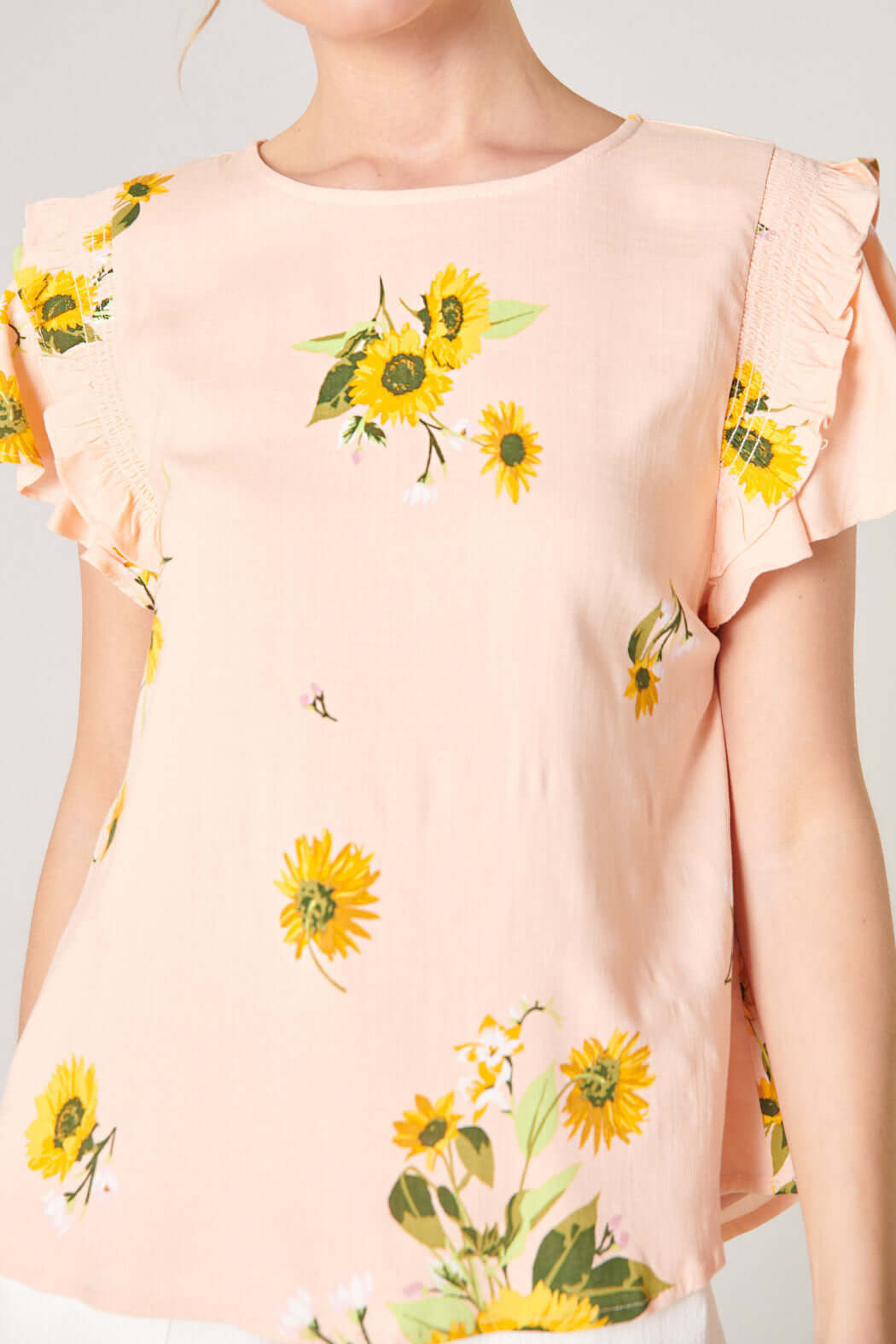 DAISY MARIE TOP in blush yellow with sunflower print and ruffle details, perfect for a chic spring look.