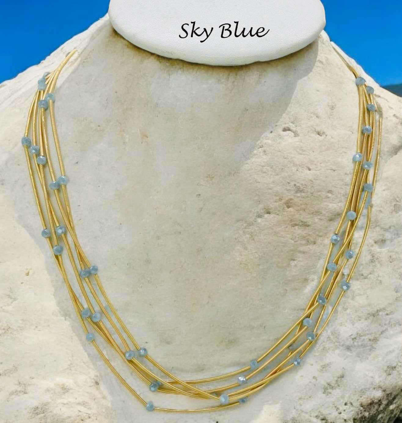 Sky blue Pretty Strands Necklace by Nine with gold tone multi strands and glass beads, 22 inches adjustable.